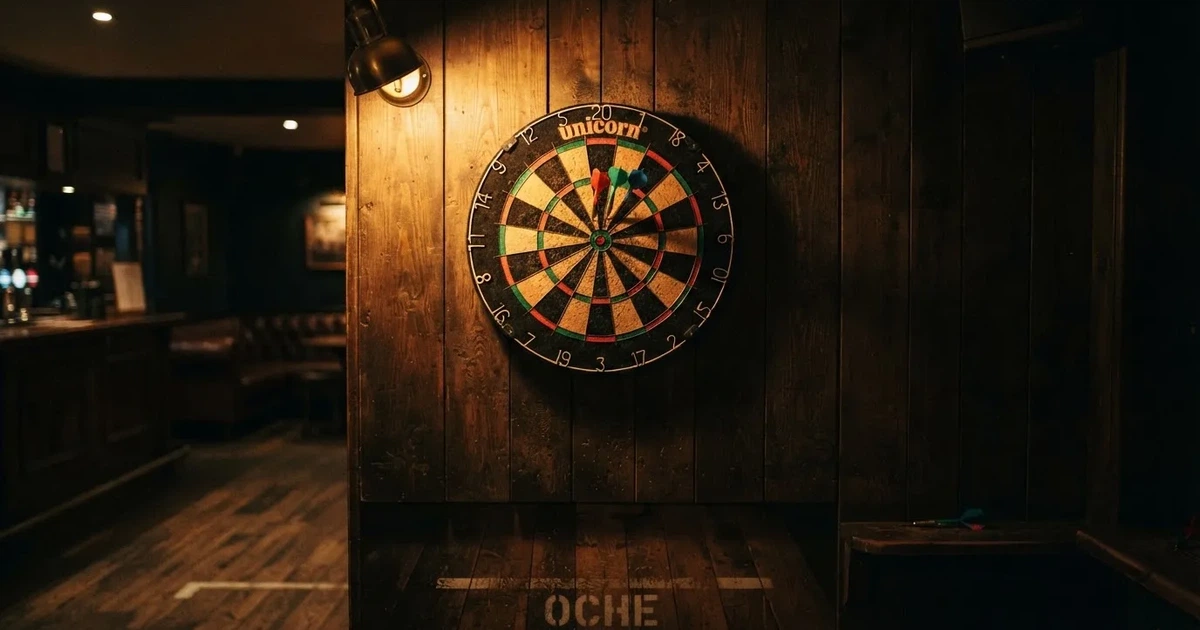 Eine Dartscheibe an einer Holzwand in einem schwach beleuchteten Raum, drei Pfeile stecken nahe der Mitte, warmes Licht von der Seite.